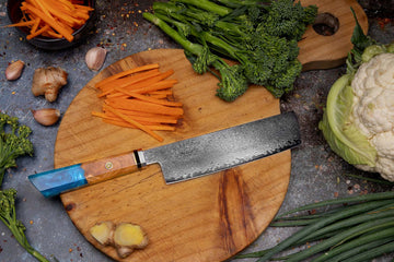 Nakiri knife with prepared vegetables on a wooden cutting board