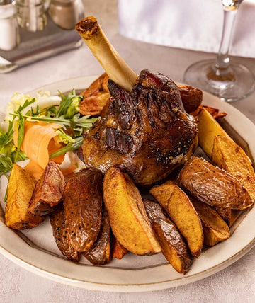 Roasted lamb shank served with crispy roasted potatoes