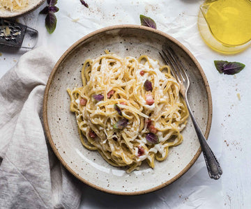 Spaghetti carbonara ingredients with pancetta and chef knife