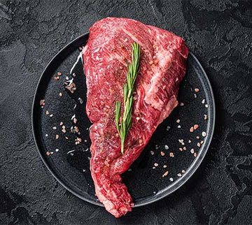 Raw tri-tip steak with fresh rosemary